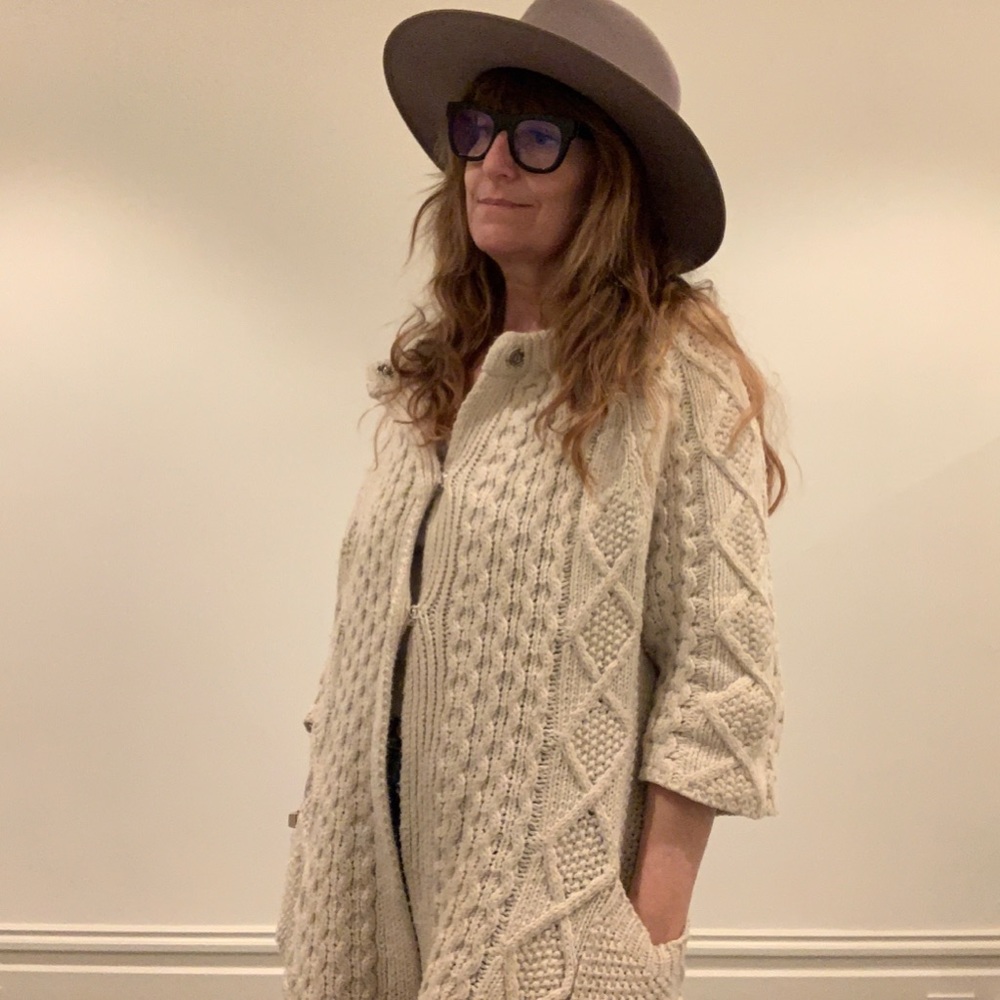 Oversize fisherman style cable cardigan. 3 snap buttons from top.
